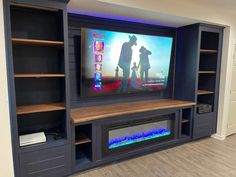 an entertainment center with built - in shelves and a flat screen tv mounted on the wall