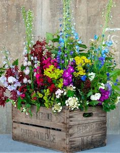 flowers in wooden crates are arranged on the table and placed next to eachother