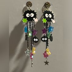 a pair of dangling earrings with eyes and stars