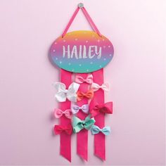 Featuring glittery font and shining sparkles, this rainbow bow holder is perfect for your little hair bow enthusiast! Includes three long pink bows for bow storage and a pink ribbon for hanging. Make this dazzling design one-of-a-kind when you personalize with her name! Color: Multicolor. Personalized Family Wall Art, Bow Storage, Name Wall Decor, Bow Holders, Organizing Hair Accessories, Rainbow Bow, Headband Holder, Hair Bow Holder, Family Wall Art