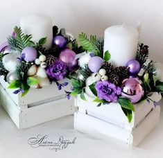 two white boxes with purple and green decorations on them, one is filled with candles