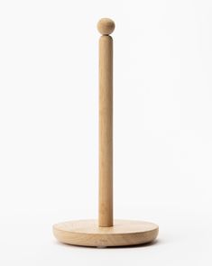 a wooden object on a white surface with a stick sticking out of it's center