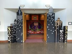 an entrance to a church decorated with black and white paper mache buildings on either side