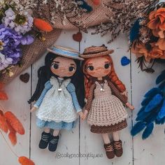 two crocheted dolls sitting next to each other on top of a wooden floor