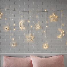 a white brick wall with stars and moon string lights