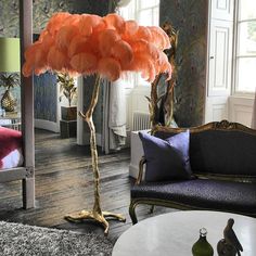 a living room filled with furniture and a tall pink feather lamp on top of a table