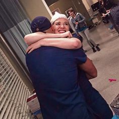 two people hugging each other in an airport