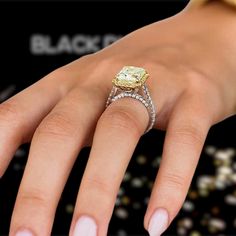 a close up of a person's hand with a diamond ring on her finger