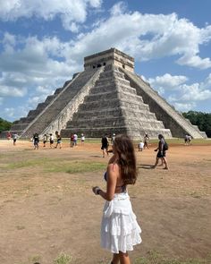 a woman standing in front of an ancient pyramid