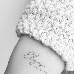 a woman's arm with the word love tattooed on it