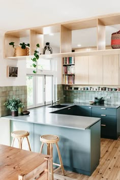 a kitchen with wooden flooring and blue counter tops next to an open book shelf