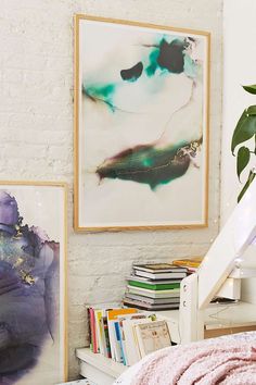 a bed room with a neatly made bed and paintings on the wall