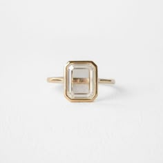 a gold and white diamond ring sitting on top of a white surface with no background