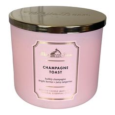 a pink candle with a gold lid and label on the top that says champagne toast