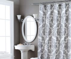 a bathroom with a sink, mirror and shower curtain in grey color scheme on the wall