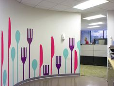 an office cubicle with fork and spoon wall decals on the walls behind it