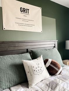 a football pillow sitting on top of a bed next to a wall hanging above it