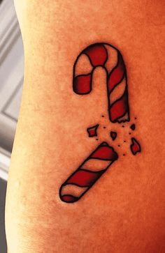 a candy cane tattoo on the side of a woman's stomach