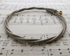 a close up of a bracelet on top of sheet music