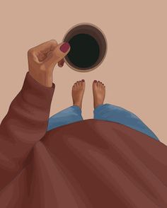 a person laying in bed with their feet up and holding a coffee cup