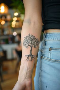 a woman's arm with a tree tattoo on it