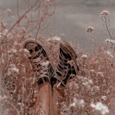 a person standing in tall grass with their feet up