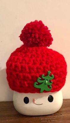 a red knitted hat with a green tree on it