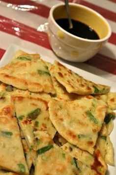 there are many flat breads on the plate with a cup of coffee in the background