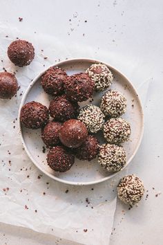 a plate full of chocolate truffles sitting on top of a white table cloth