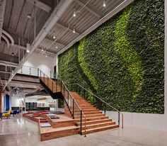 a large living wall in the middle of a building with stairs leading up to it