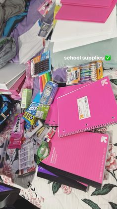 a pile of school supplies sitting on top of a bed