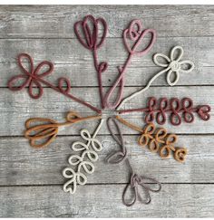 a bunch of flowers that are on top of a wooden table with string attached to them