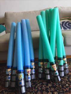 several blue and green candles sitting on top of a rug in front of a couch