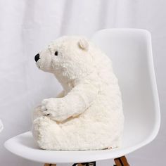 a stuffed polar bear sitting on a white chair