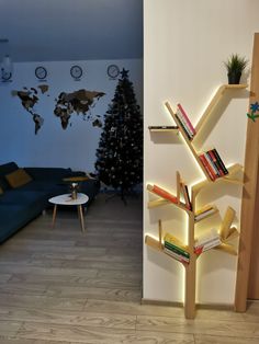 a book shelf with books on it in a living room next to a christmas tree