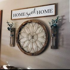 a clock mounted to the side of a wall next to two vases with flowers