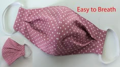 a pink and white polka dot cloth face mask with matching bow tie, ear tag and headband