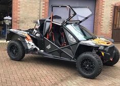 an off road vehicle parked in front of a garage