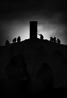 silhouettes of people sitting on top of a hill with a cross in the background