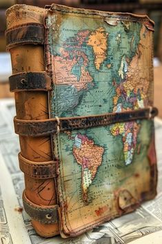 an old suitcase is sitting on top of some newspaper with a map in the middle