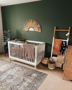 a baby's room with green walls and white crib, rugs and decor