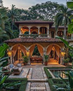 an outdoor living area with a pool in the middle and lots of greenery around it