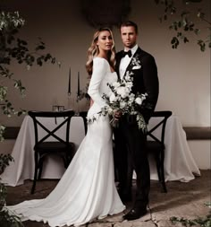 a bride and groom posing for a photo in front of a table with white flowers