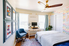 a bed room with a neatly made bed next to a window and a ceiling fan