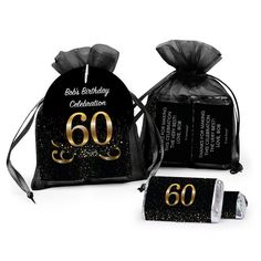 two black and gold birthday bags with the number 60 on them, one bag is filled with chocolates