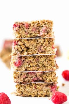 raspberry granola bars stacked on top of each other with fresh raspberries