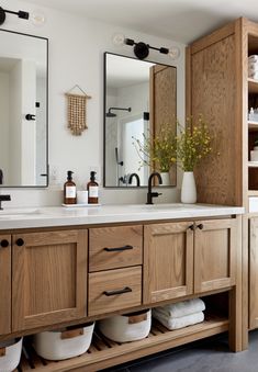 a bathroom with wooden cabinets and two sinks