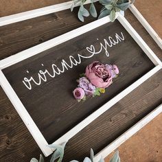 a wooden sign with flowers on it