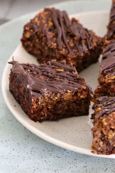 a plate that has some kind of dessert on it with chocolate frosting and nuts