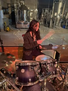 a woman with long hair playing drums on stage